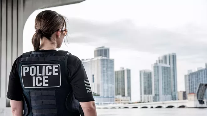 An ICE ERO officer looks out over the Miami skyline.