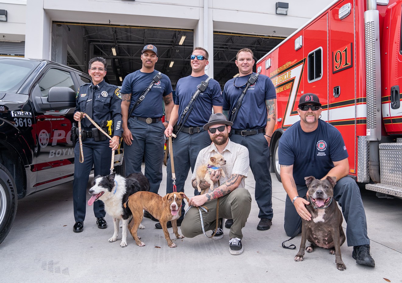Mick Rude, holding dog, joins members of Boynton Beach Police Department and Palm Beach County Fire Rescue.