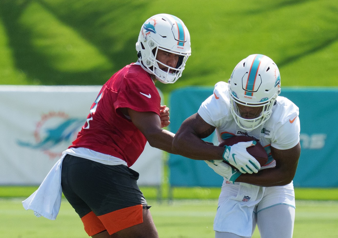 Tua Tagovailoa handing off to Salvon Ahmed during Miami Dolphins training camp in 2021