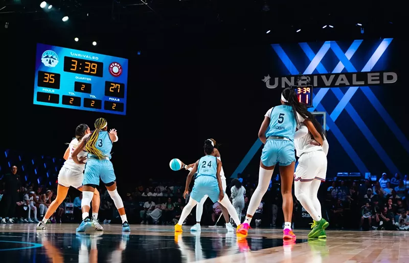 Image: two women's basketball teams play on a court