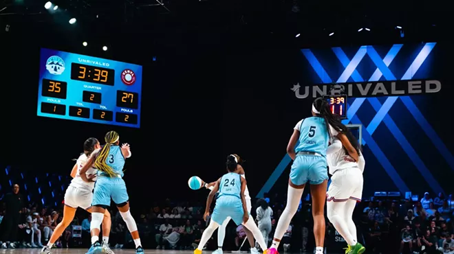 two women's basketball teams play on a court