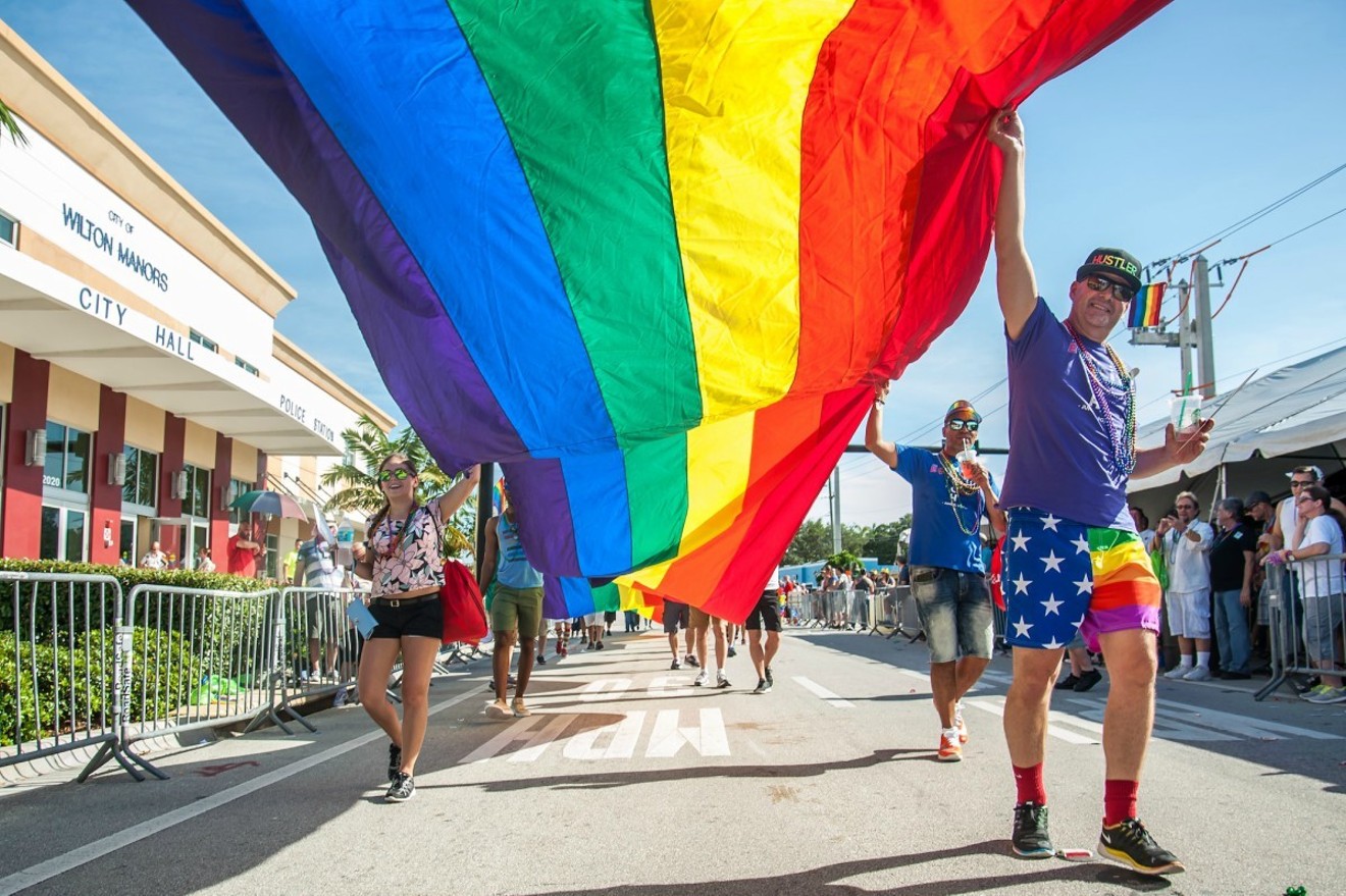Wilton Manors pride parade participants stroll past city hall.