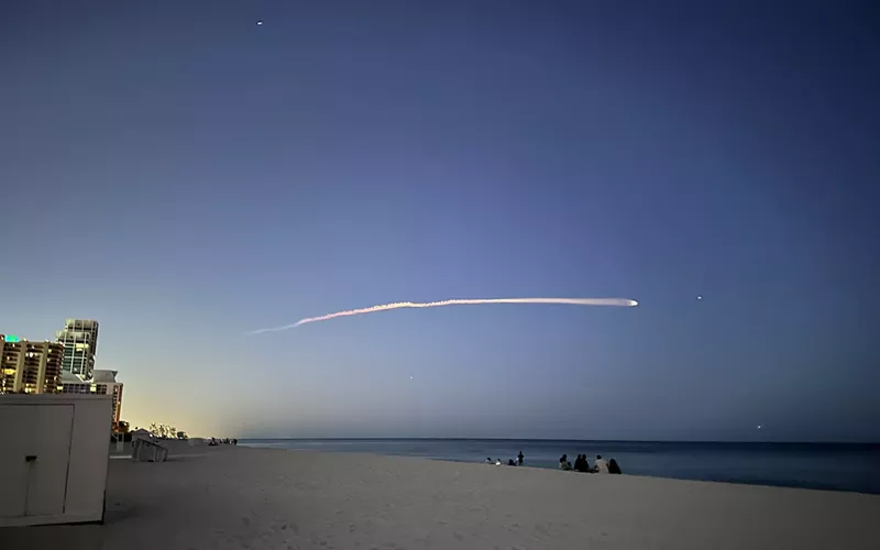Image: A SpaceX rocket streaking across the night sky, viewed from Miami Beach